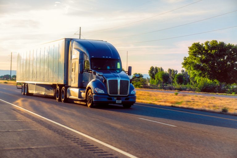 Big freight truck on the open highway in front of an amazing sunset